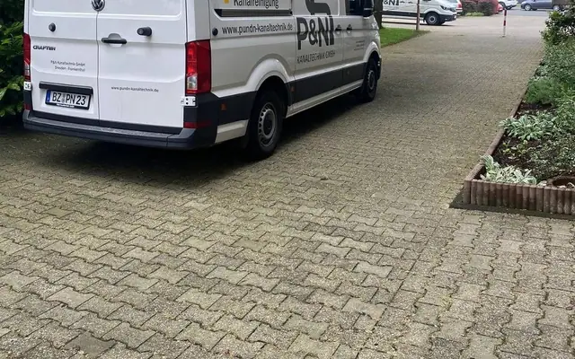 Einsatzfahrzeug des Partnerbetriebs P&N Kanaltechnik vor einer Wohnanlage